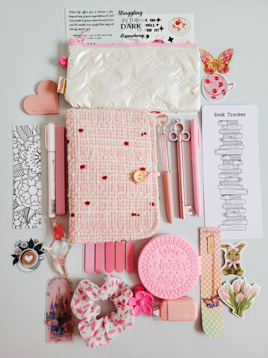 Elegant holiday gift bookish bundle flatlay featuring a pink tweed notebook cover, pastel pens, plush pencil pouch, book tracker, bookmarks, stickers, and aesthetic pink stationery. A premium Christmas gift set for book lovers, writers, and journal enthusiasts