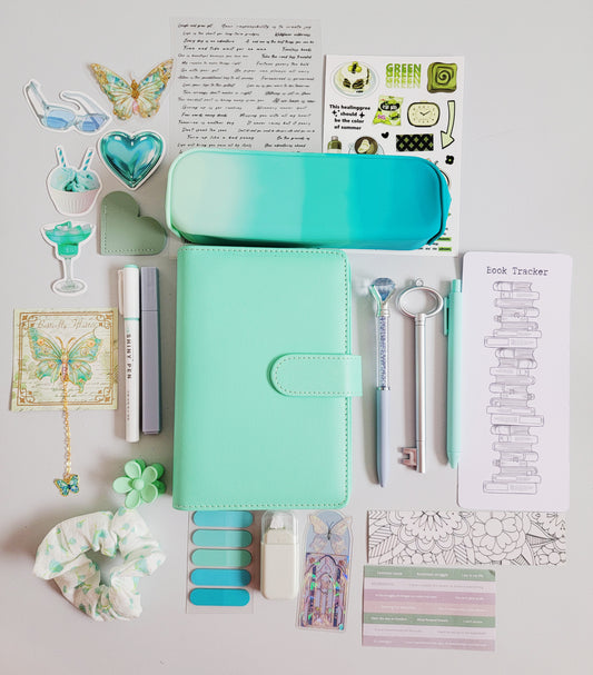 Tiffany-color bookish holiday gift bundle flatlay featuring a Tiffany blue planner cover, gradient pencil case, book tracker, pastel pens, butterfly accessories, scrunchie, stickers, tabs, and aesthetic stationery items. A cozy and elegant Christmas gift set for book lovers, journalers, and students.