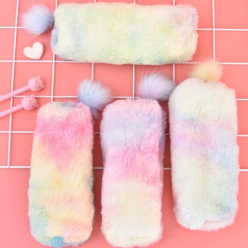 Rainbow plush pencil pouches with fluffy pom‑pom pull tabs in pastel gradient colors (pink, blue, lavender) arranged on a white keyboard and pink desk — cozy, fuzzy aesthetic ideal for stationery and bookish setups.