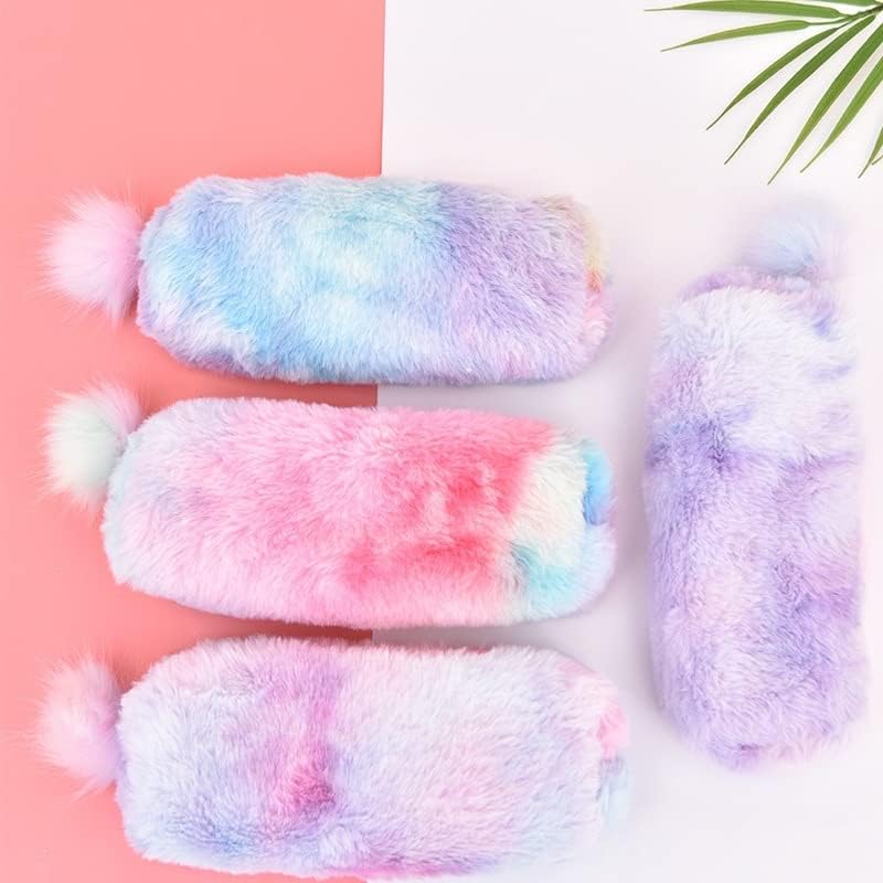 Rainbow plush pencil pouches with fluffy pom‑pom pull tabs in pastel gradient colors (pink, blue, lavender) arranged on a white keyboard and pink desk — cozy, fuzzy aesthetic ideal for stationery and bookish setups.