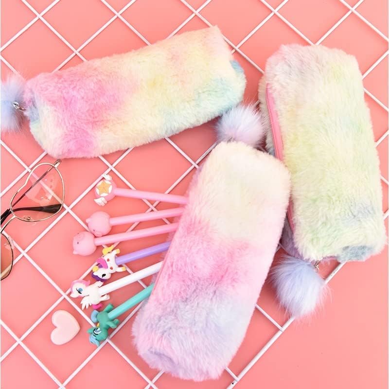 ainbow plush pencil pouches with fluffy pom‑pom pull tabs in pastel gradient colors (pink, blue, lavender) arranged on a white keyboard and pink desk — cozy, fuzzy aesthetic ideal for stationery and bookish setups.
