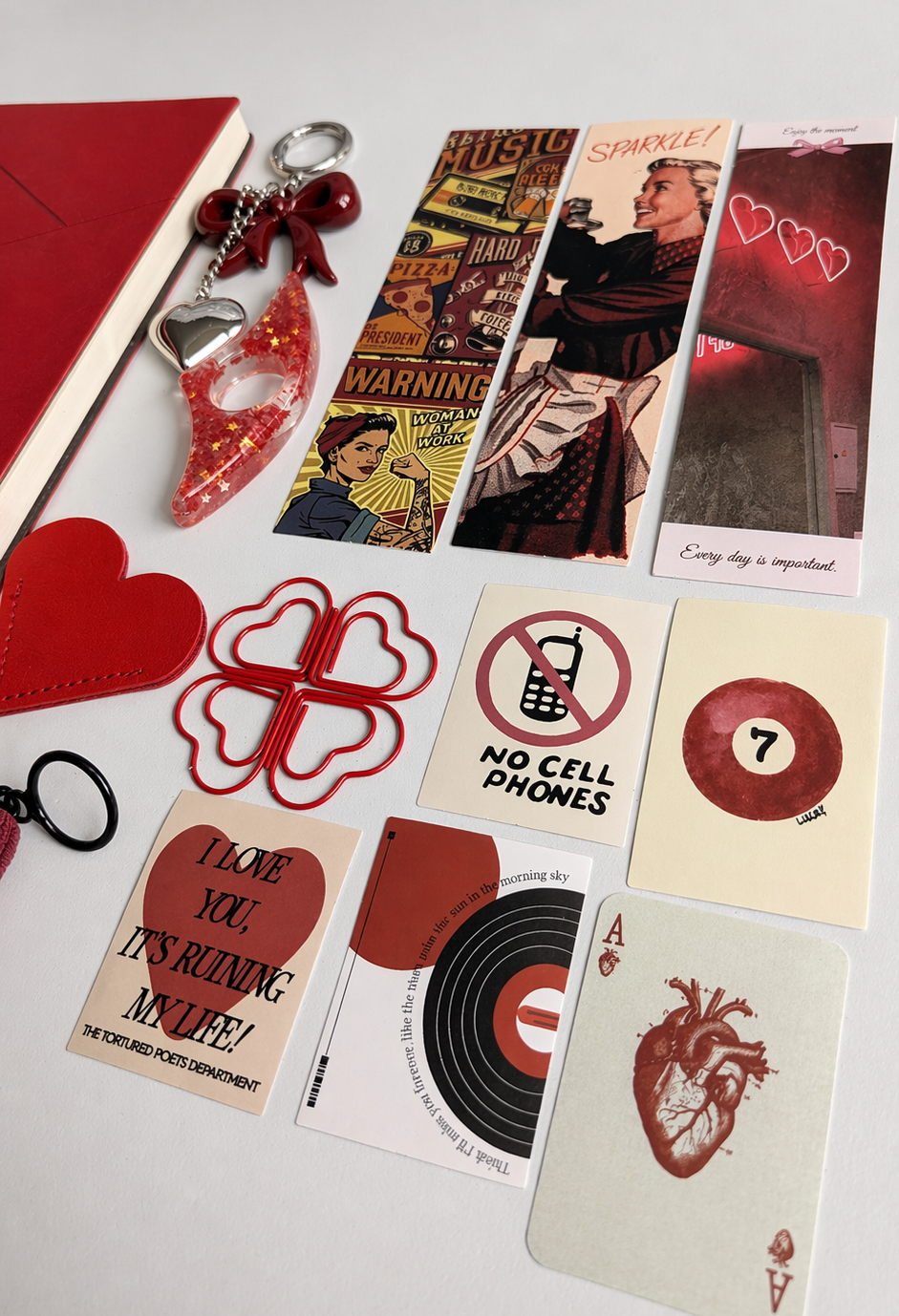 Collection of decorative items including cards, keychains, and paper clips on a white background