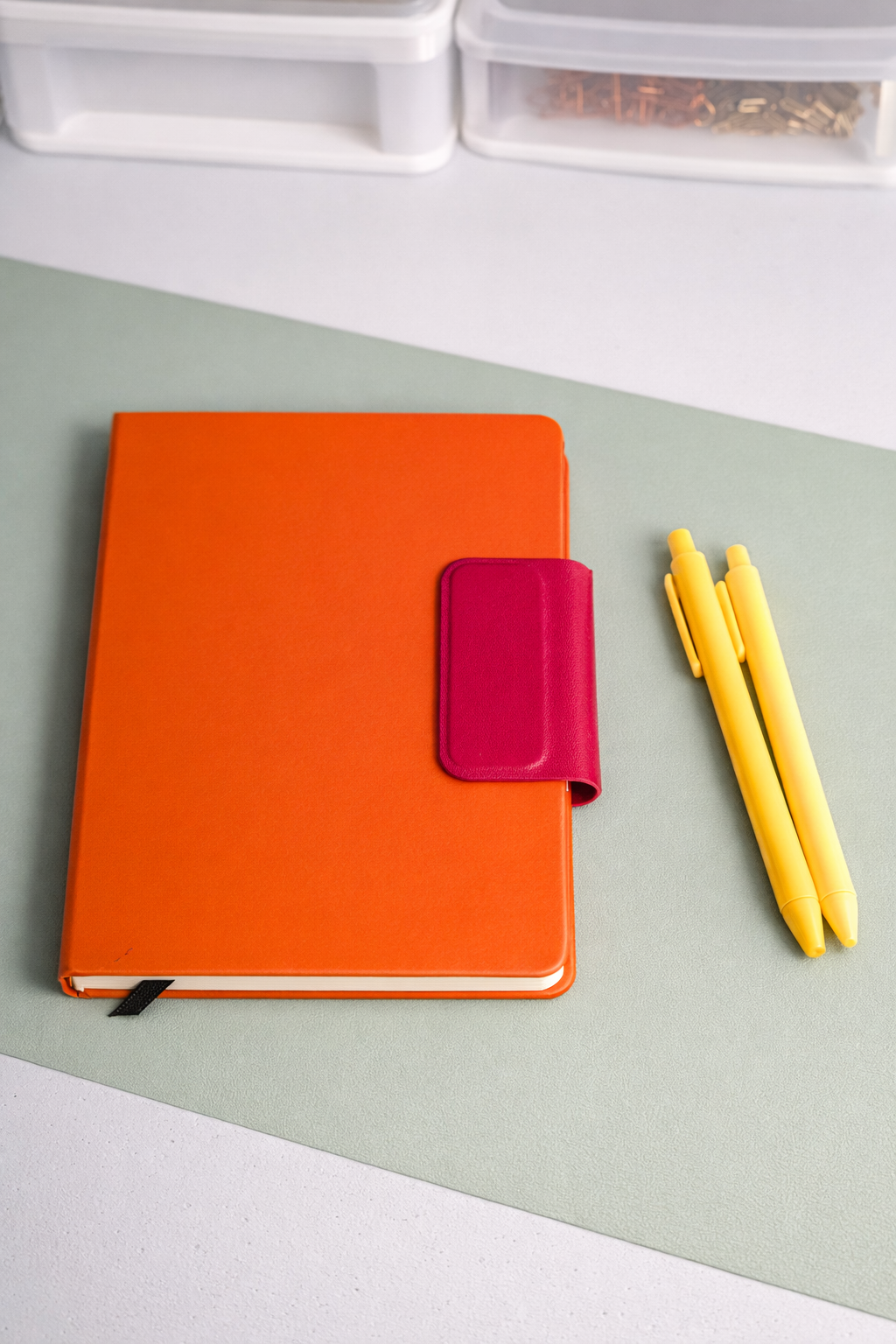 Bright orange notebook with magnetic closure a a strap bookmark